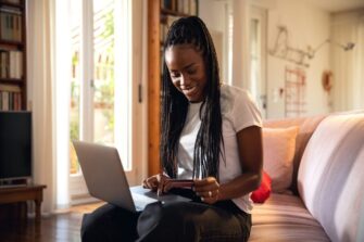 Woman-shopping-online-using-credit-card-while-relaxing-on-sofa-at-home_LeoPatrizi.jpg