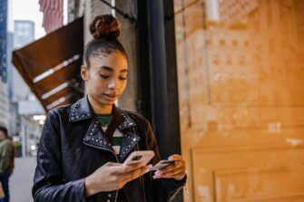 Young-woman-making-card-purchase-on-smart-phone-in-city_Riska.jpg