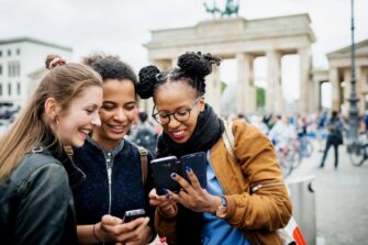 Groupof-friends-traveling-to-Berlin-Germany-looking-at-smart-phone_Hinterhaus-Productions.jpg
