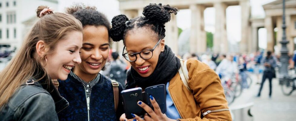 Groupof-friends-traveling-to-Berlin-Germany-looking-at-smart-phone_Hinterhaus-Productions.jpg